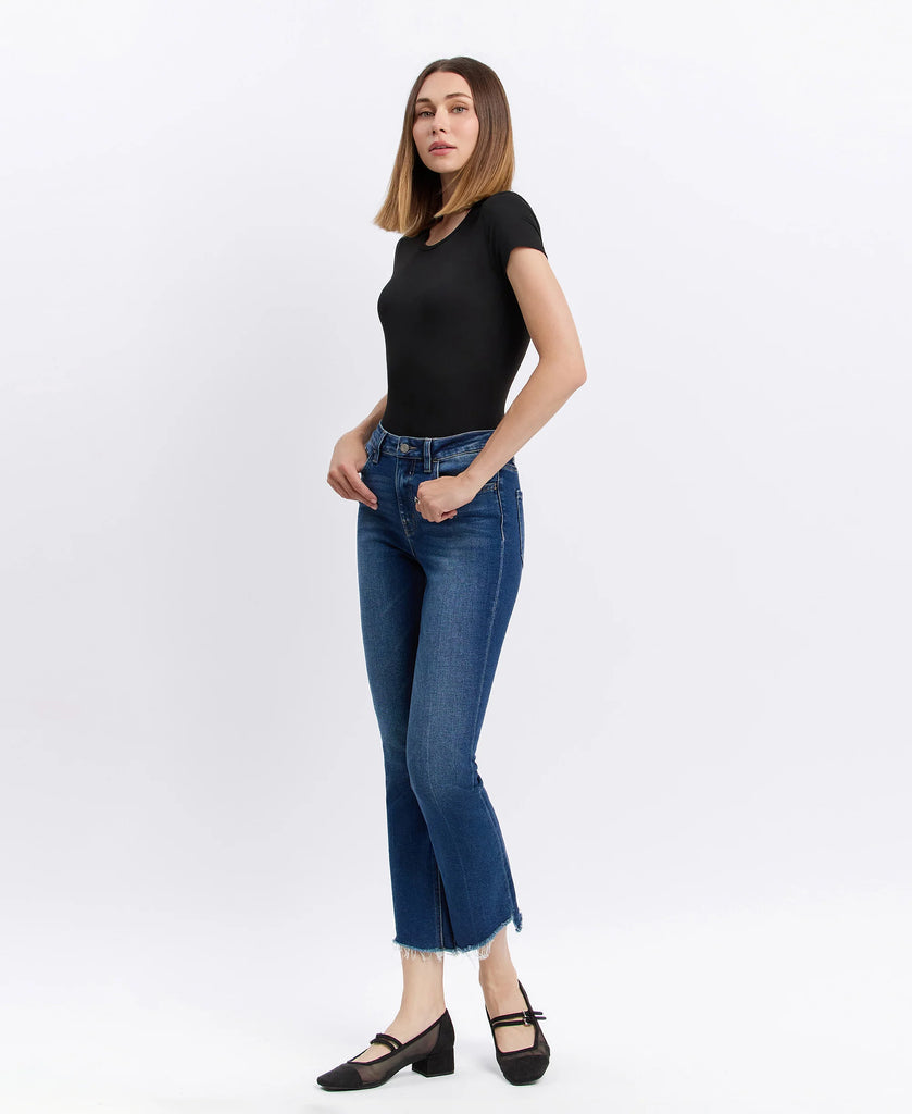 Lovervet cropped flare jeans in medium-dark wash with raw frayed hem, styled with a black fitted top and black ballet flats.