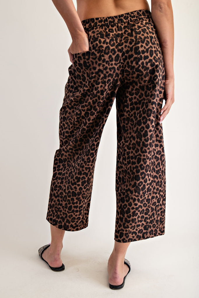Leopard print pants worn by a person on a plain background