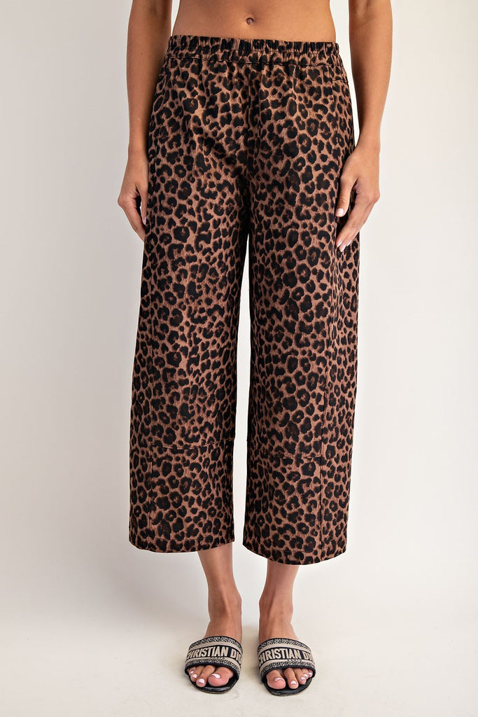 Leopard print pants worn by a person on a plain background