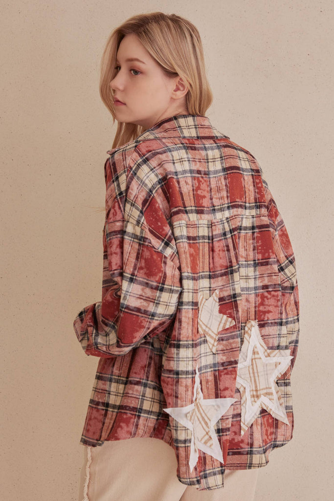 Person wearing a red plaid shirt with star patterns on a beige background