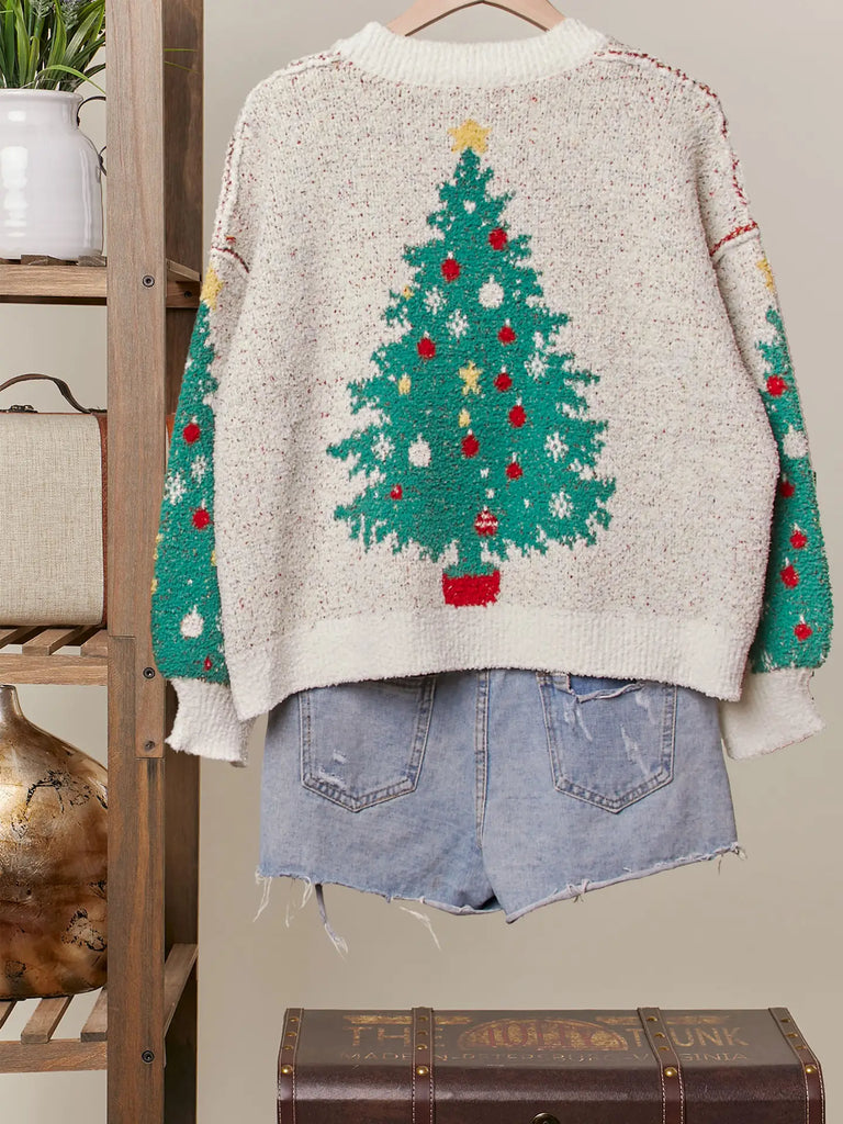 A fuzzy white knit cardigan with a green Christmas tree, red ornament, and yellow star pattern. It has a V-neckline, long sleeves, and a button-up front.