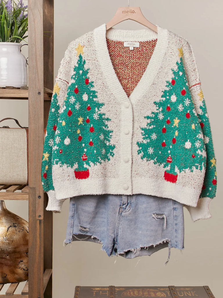 A fuzzy white knit cardigan with a green Christmas tree, red ornament, and yellow star pattern. It has a V-neckline, long sleeves, and a button-up front.