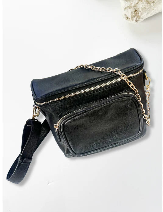 Black leather crossbody bag with gold chain strap on a light gray background