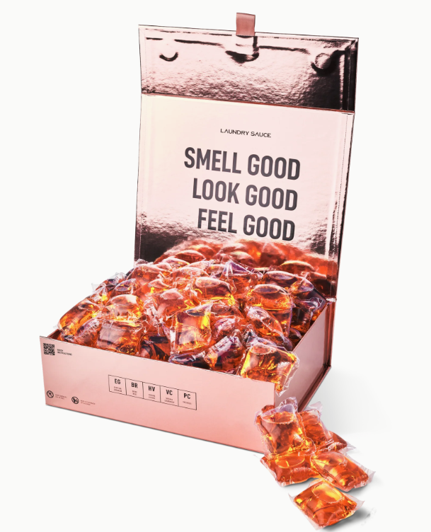 Box of orange laundry detergent pods with text 'Smell Good, Look Good, Feel Good' on a white background.