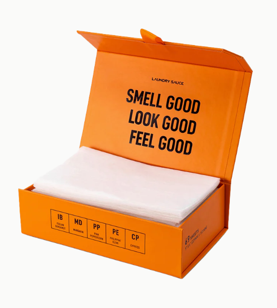 Orange box of laundry detergent with text 'Smell Good, Look Good, Feel Good' on a white background