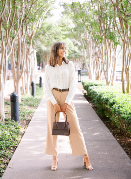 Woman walking on a sidewalk with trees and greenery in the background