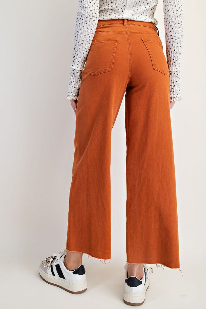 A pair of brick-colored, high-waisted, wide-leg twill pants with a soft stretch.