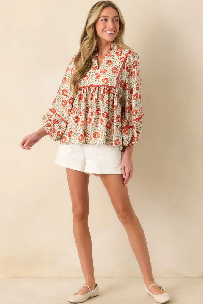 Boho peasant blouse with rust floral block print, relaxed fit, and scalloped trim on sleeves.