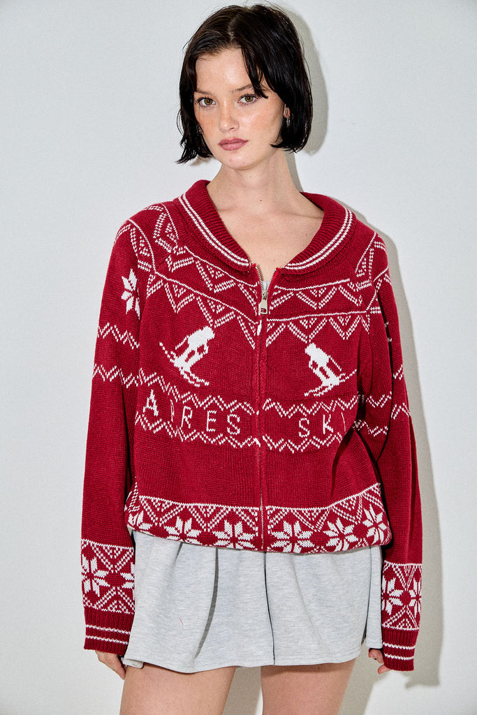 Viatrix red ski Fair Isle zip-up cardigan with white snowflake and skier motifs, featuring a wide collar and a relaxed fit.