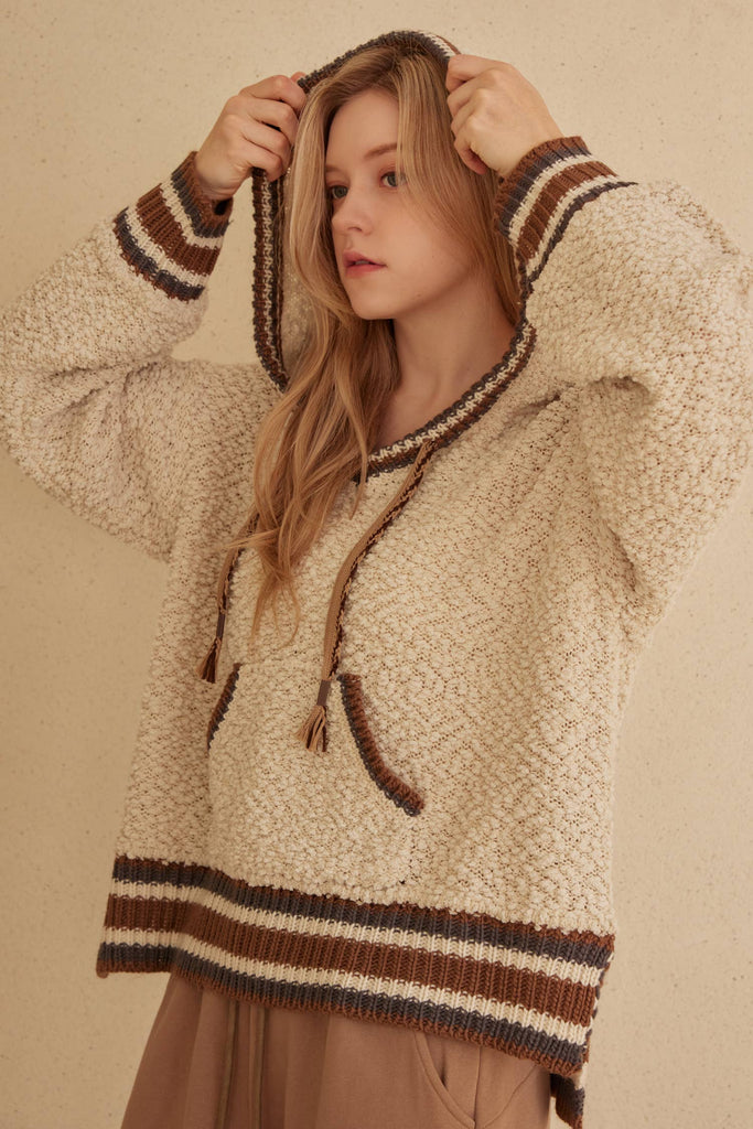 Cream hooded puff sweater with brown striped trim and kangaroo pocket.