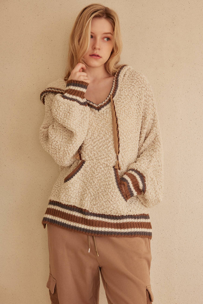 Cream hooded puff sweater with brown striped trim and kangaroo pocket.