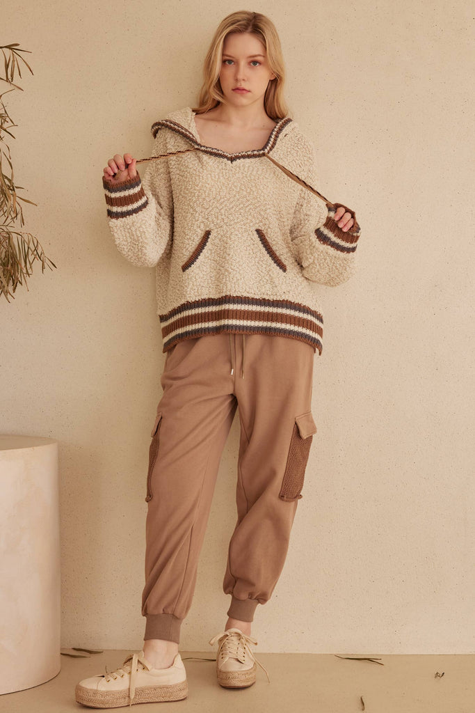 Cream hooded puff sweater with brown striped trim and kangaroo pocket.