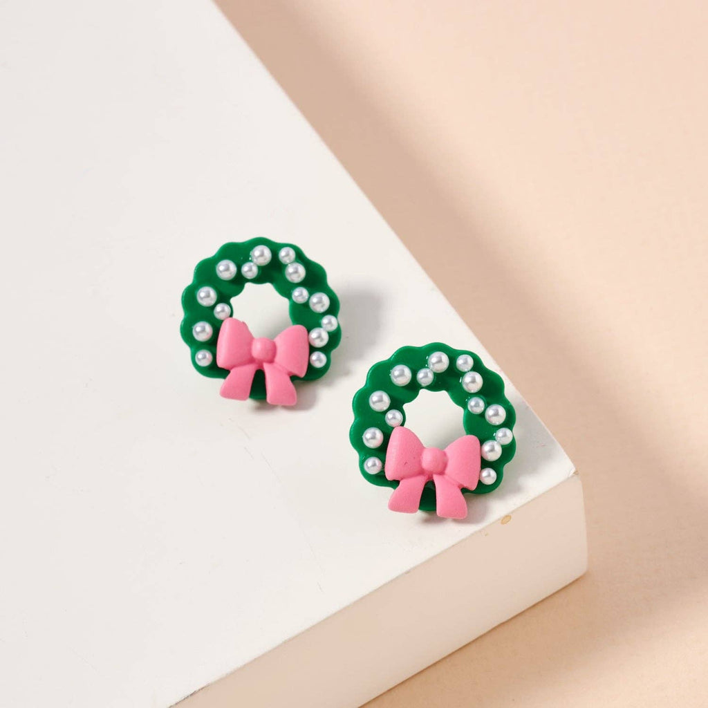 Green enamel Christmas wreath stud earrings with pearl accents and pink bows.