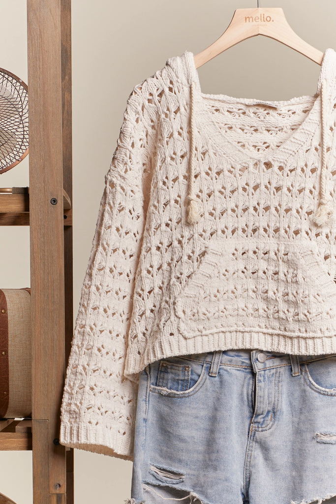 Beige lace top and denim shorts on a hanger against a neutral background