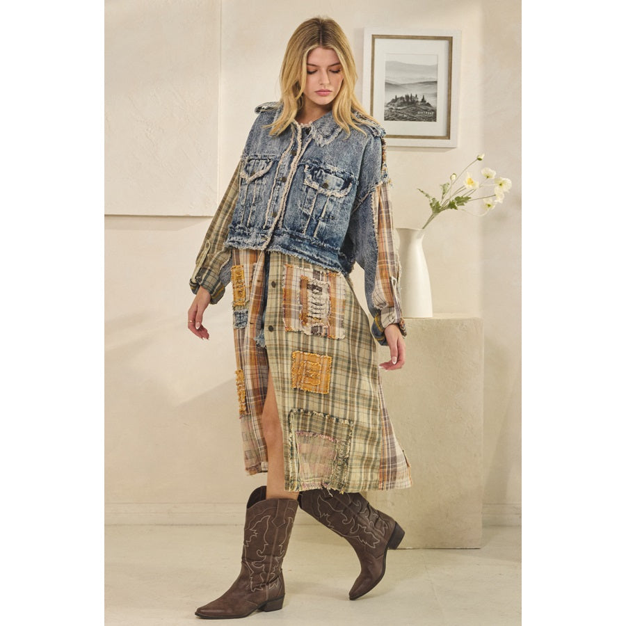 Woman wearing a denim jacket over a plaid dress with cowboy boots in an indoor setting.