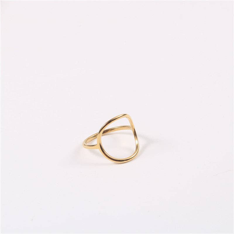  open-circle gold ring on the middle finger. The ring has a smooth, organic shape and a polished 18K gold finish, 