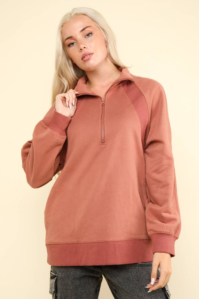 Amalie oversized sweatshirt henley knit top in mauve with half-zip and side pockets, perfect for casual wear. Stock Photo