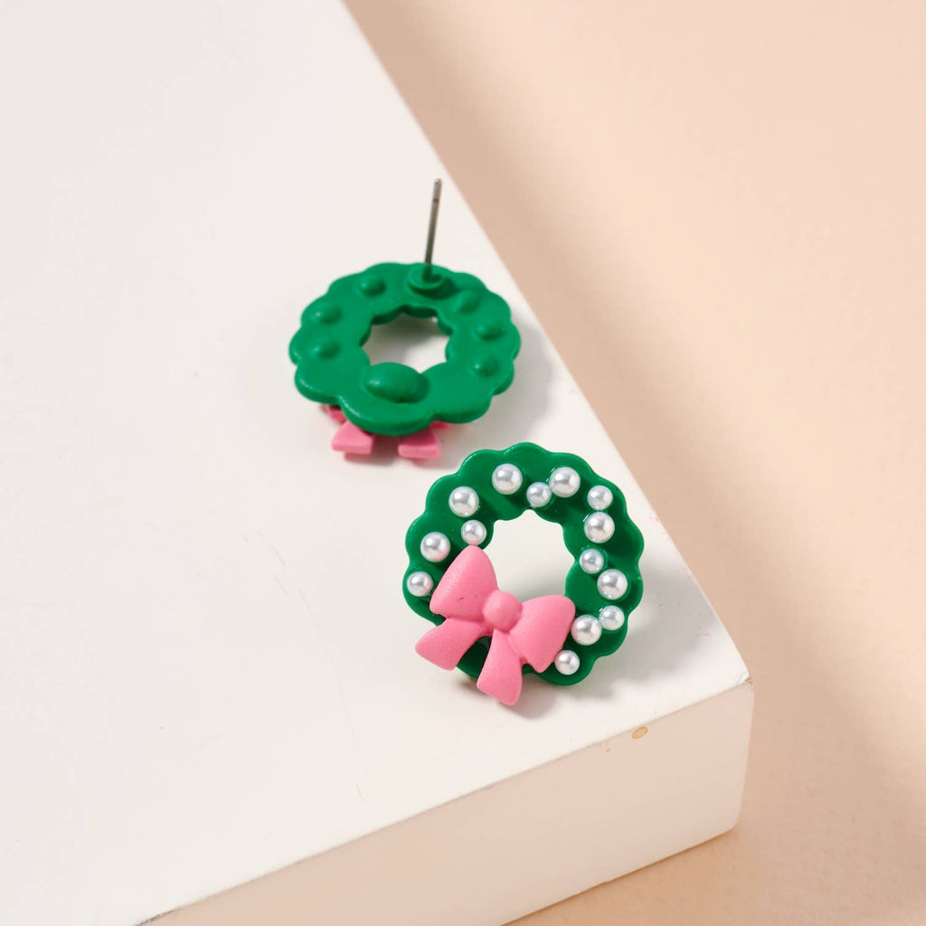 Green enamel Christmas wreath stud earrings with pearl accents and pink bows.