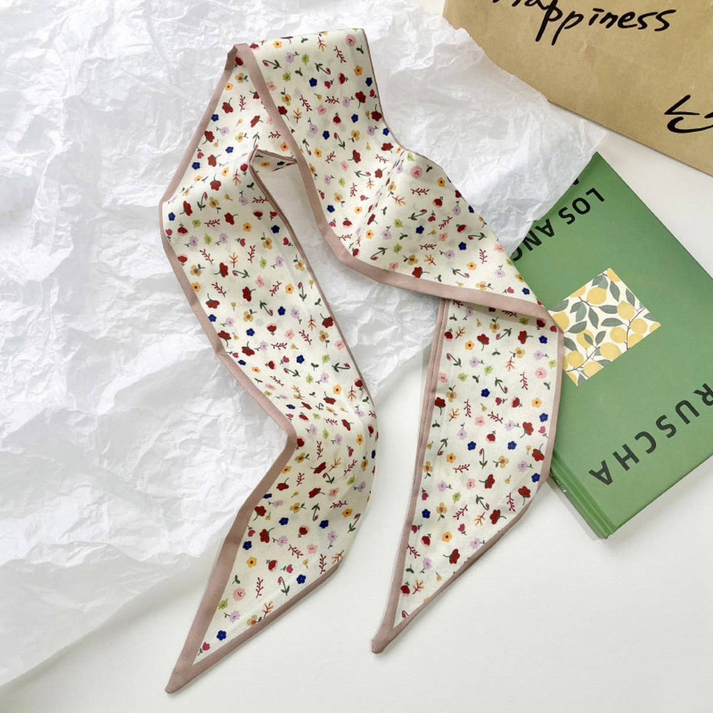 Floral patterned scarf on a textured surface with a book in the background