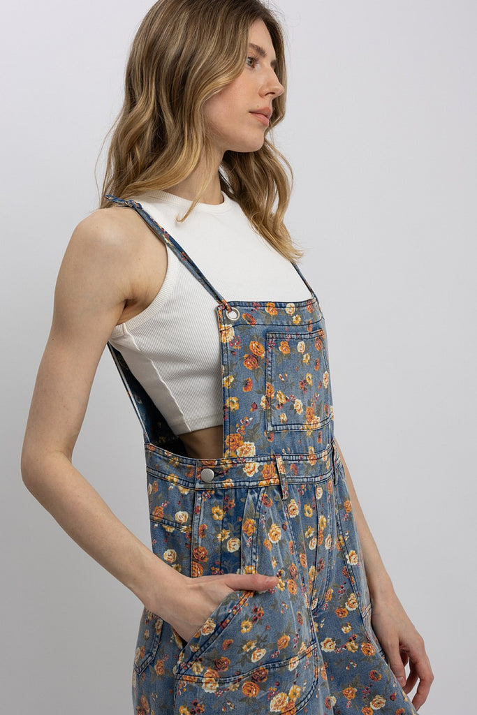 Woman wearing a floral denim dress against a plain background