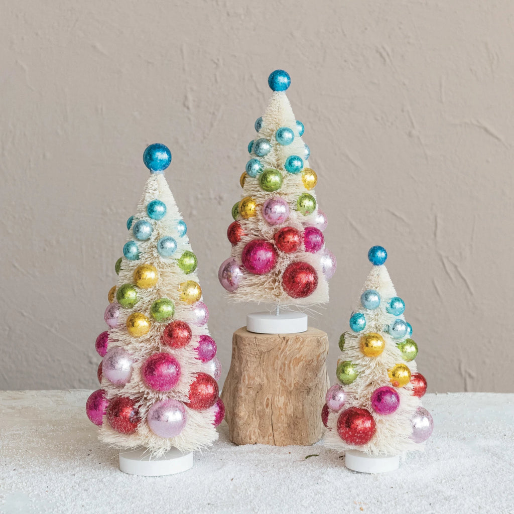 Single sisal bottle brush Christmas tree with colorful ornaments and wood base, festive tabletop holiday decoration.