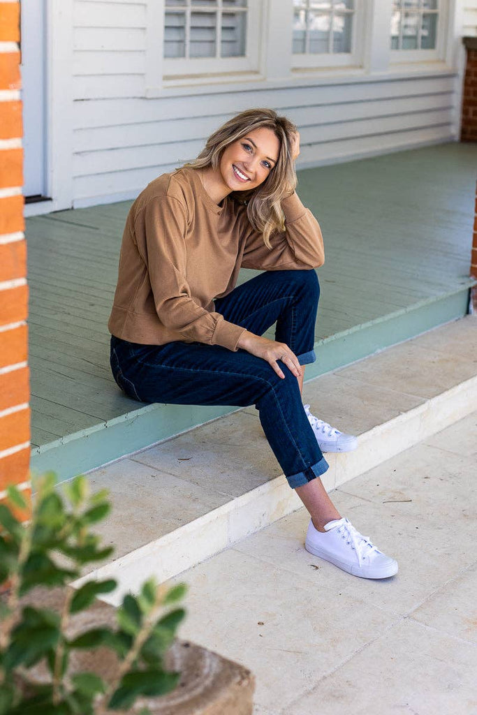 Model wearing the Brynn Camel Classic Pullover — a neutral cropped sweatshirt with crew neck and long sleeves.