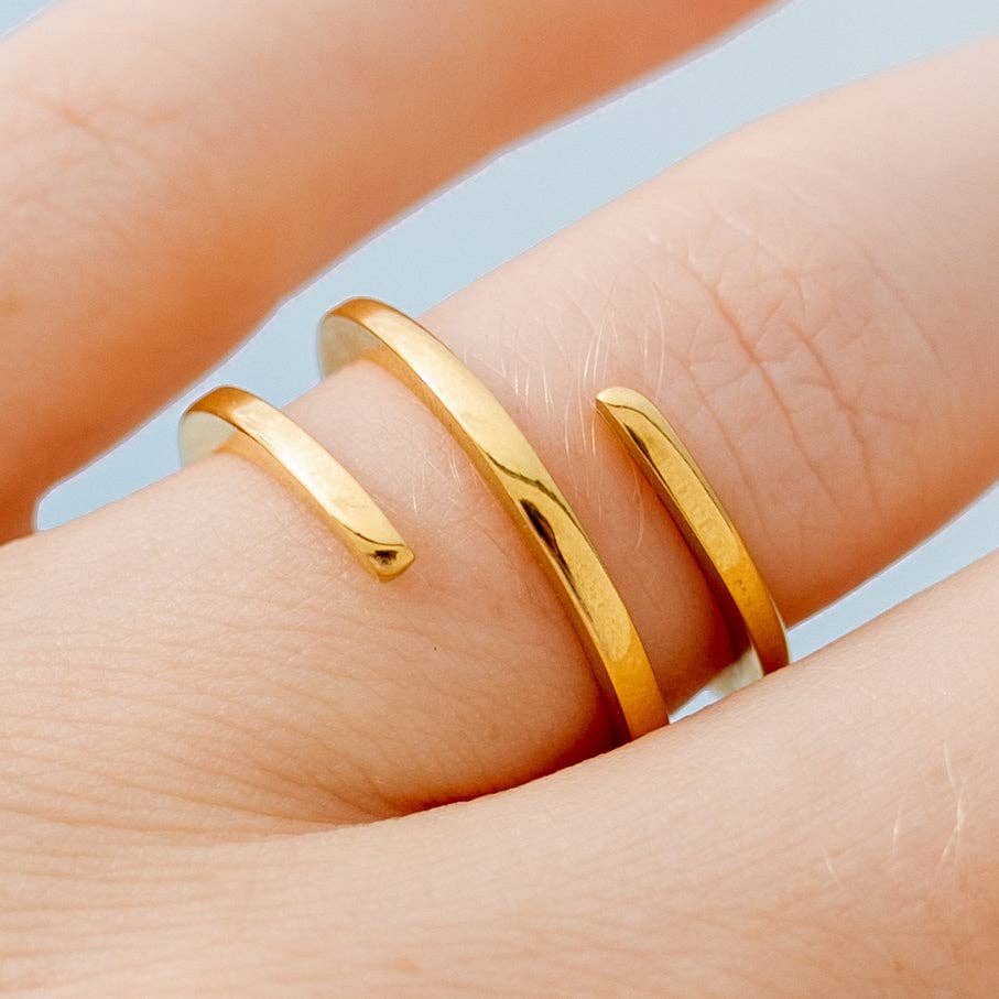 Gold ring on a finger with a light blue background