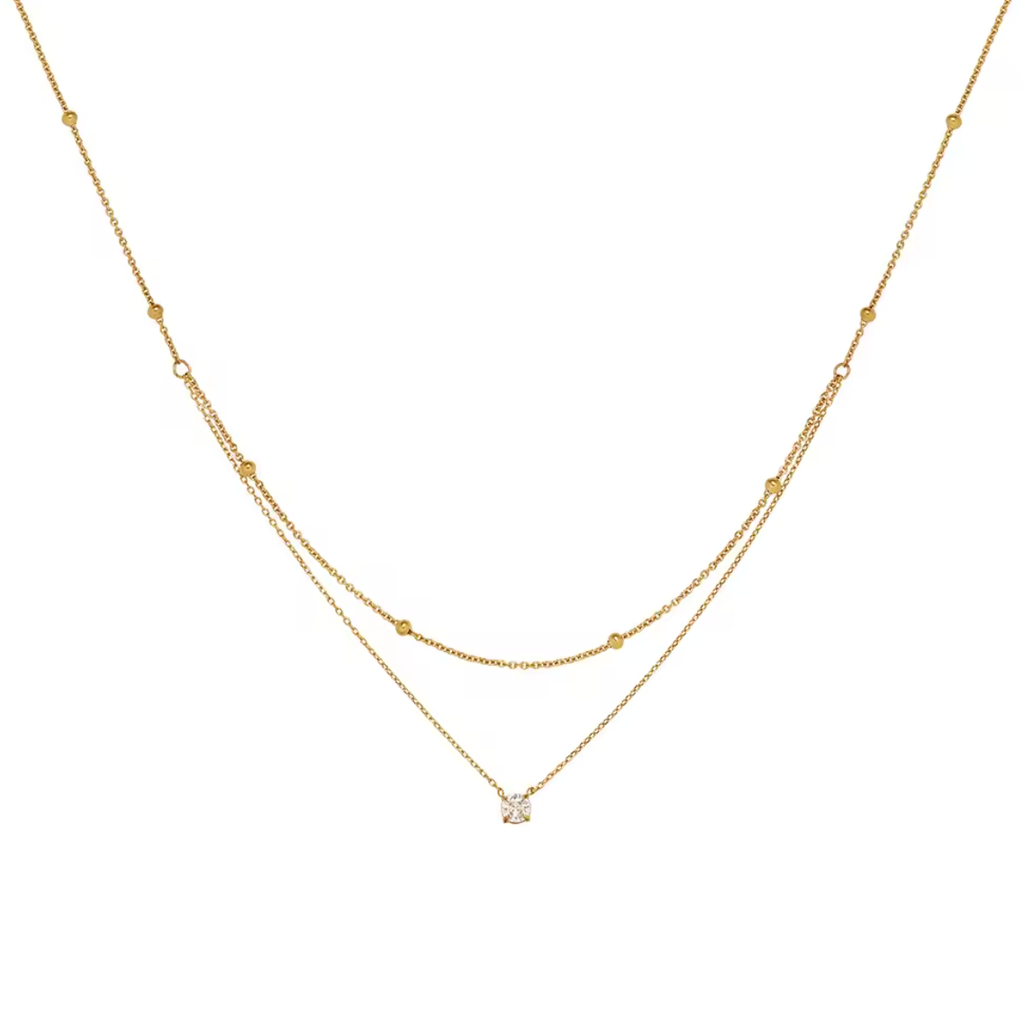 Gold necklace with a small diamond pendant on a white background