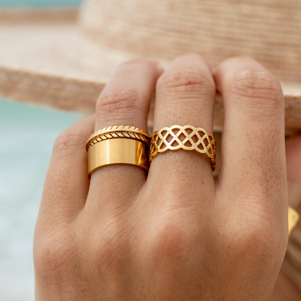 Gold rings on a hand with a blurred background