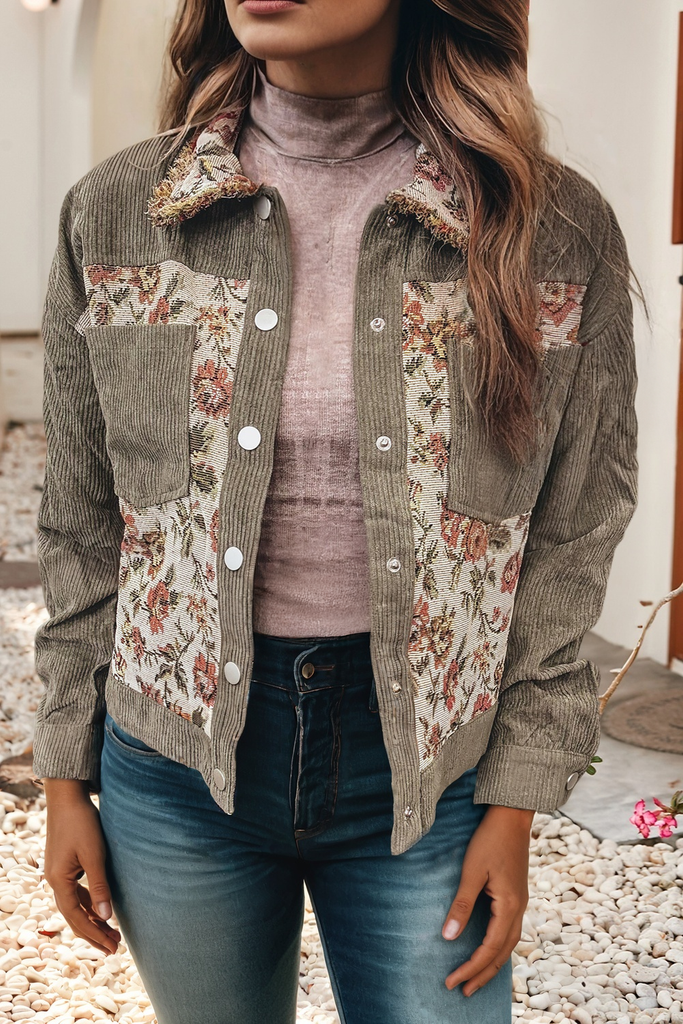 Person wearing a floral patchwork jacket over a turtleneck sweater and jeans.