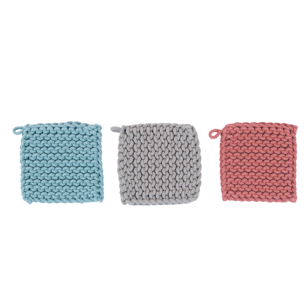 Three knitted potholders in blue, gray, and pink on a white background