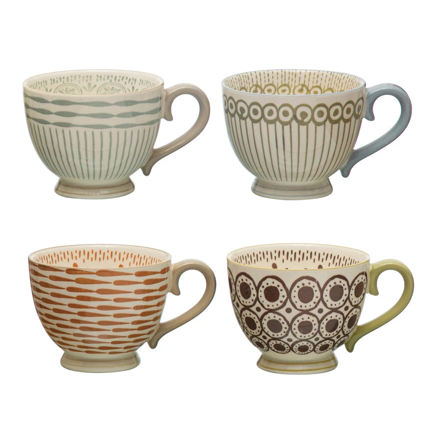 Four patterned mugs on a white background