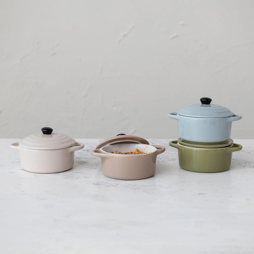 Set of ceramic cookware with lids on a light surface