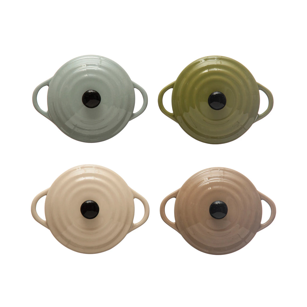 Four ceramic pots with handles in different colors on a white background