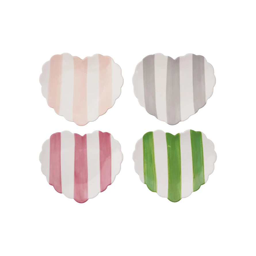 Four heart-shaped dishes with striped patterns on a white background