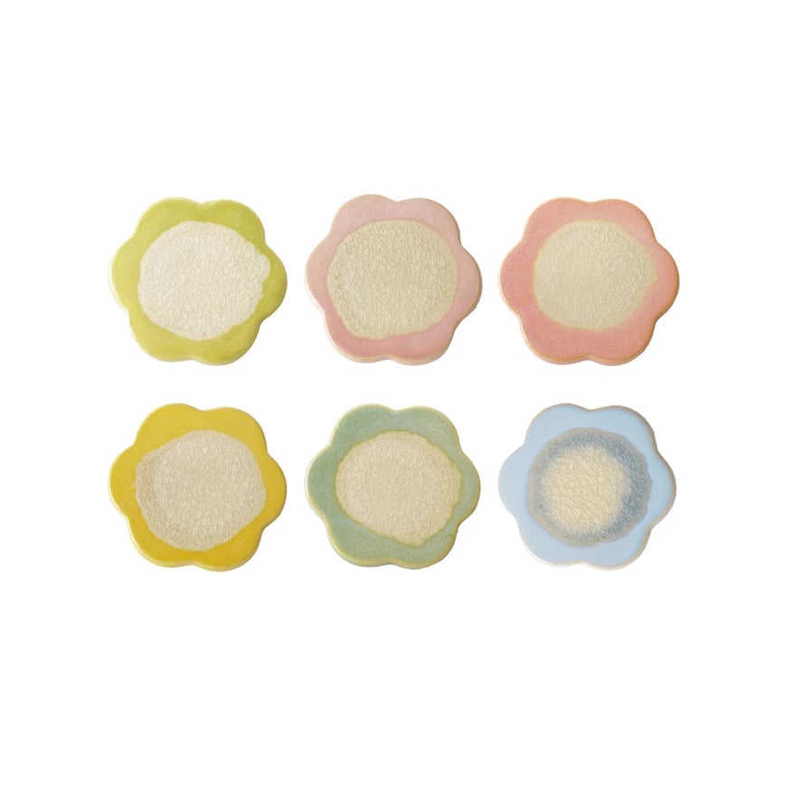 Set of six colorful flower-shaped coasters on a white background
