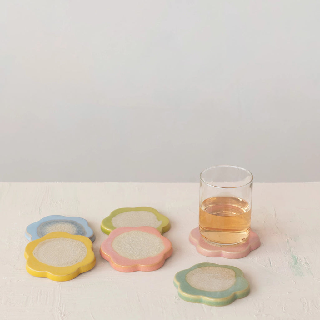 Set of colorful coasters with a glass of juice on a white surface