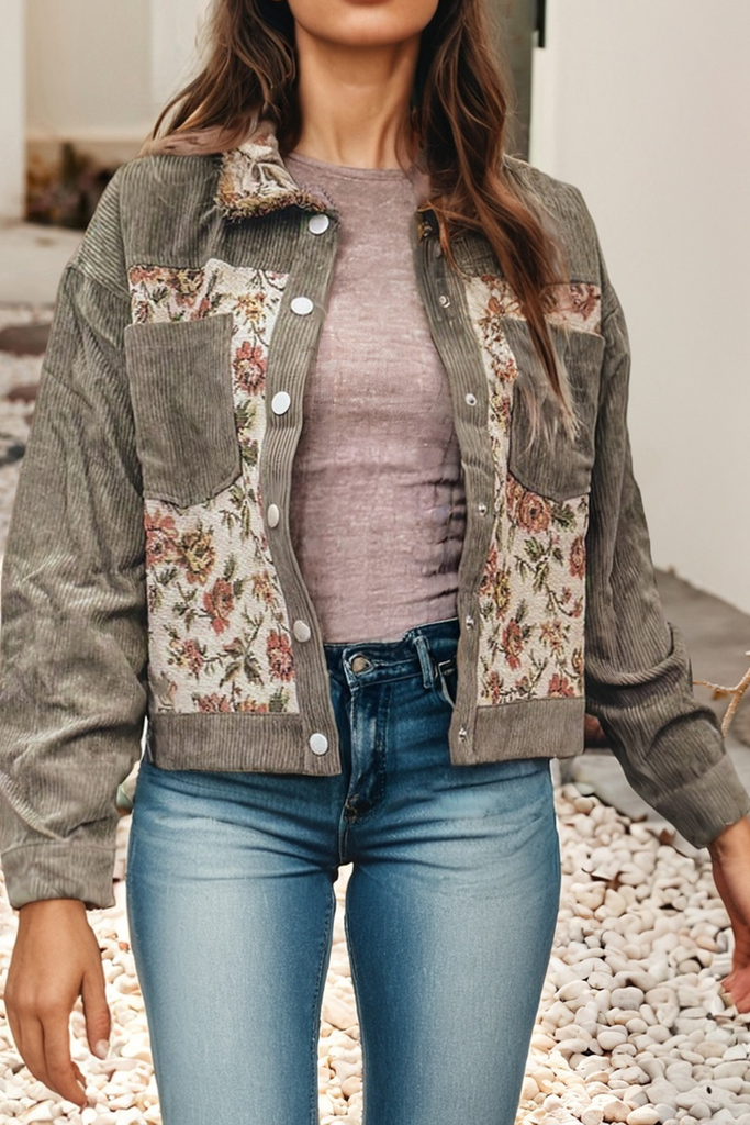 Person wearing a floral patchwork jacket over a plain shirt and jeans.
