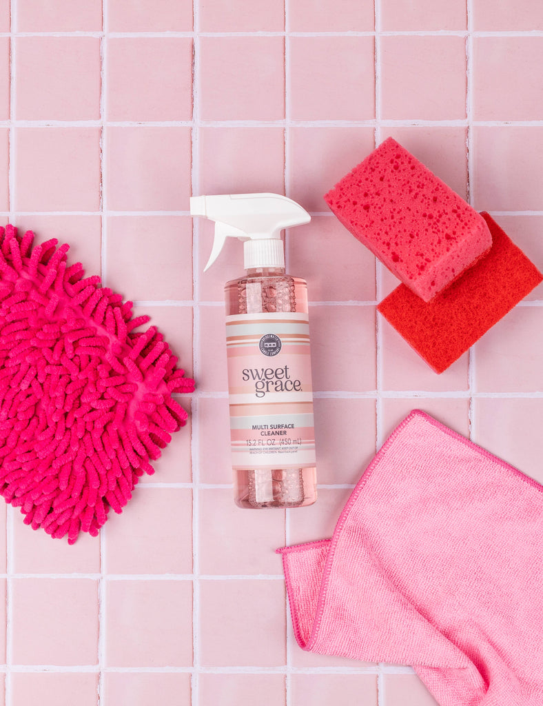 Sweet Grace beauty product with cleaning tools on a pink tiled background