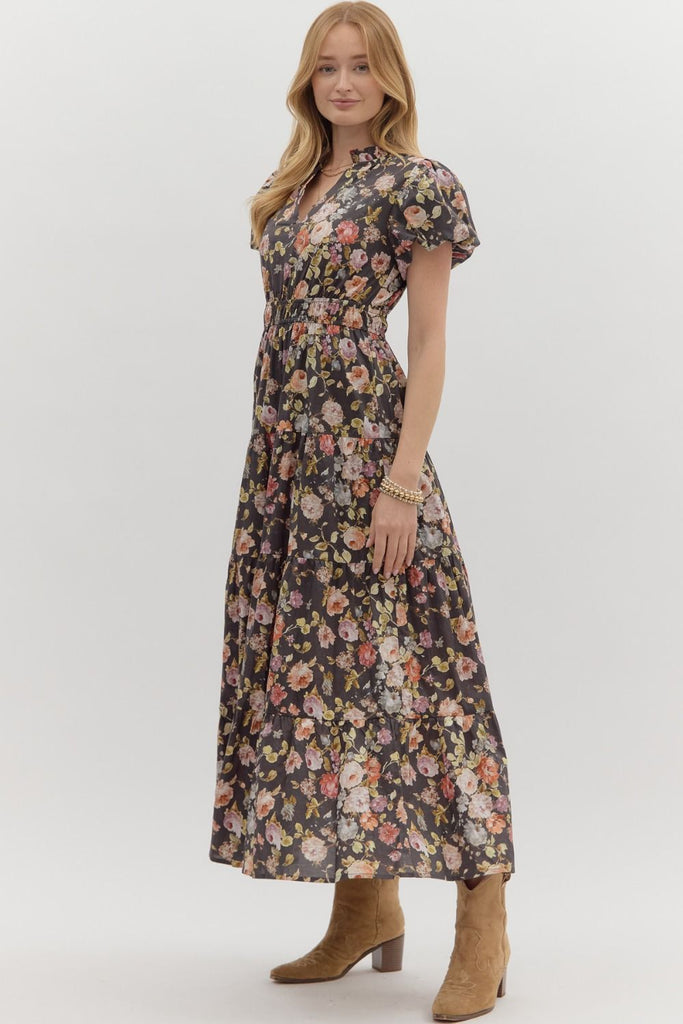 Woman wearing a floral dress with short sleeves and a collar on a white background