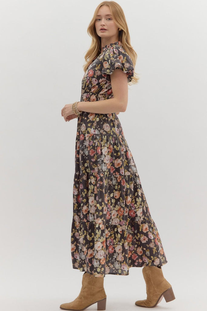 Woman wearing a floral dress with brown boots on a white background