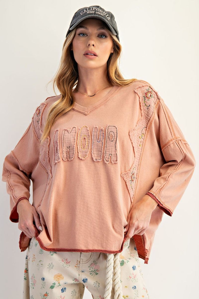 Woman wearing a pink embroidered top and cap on a white background