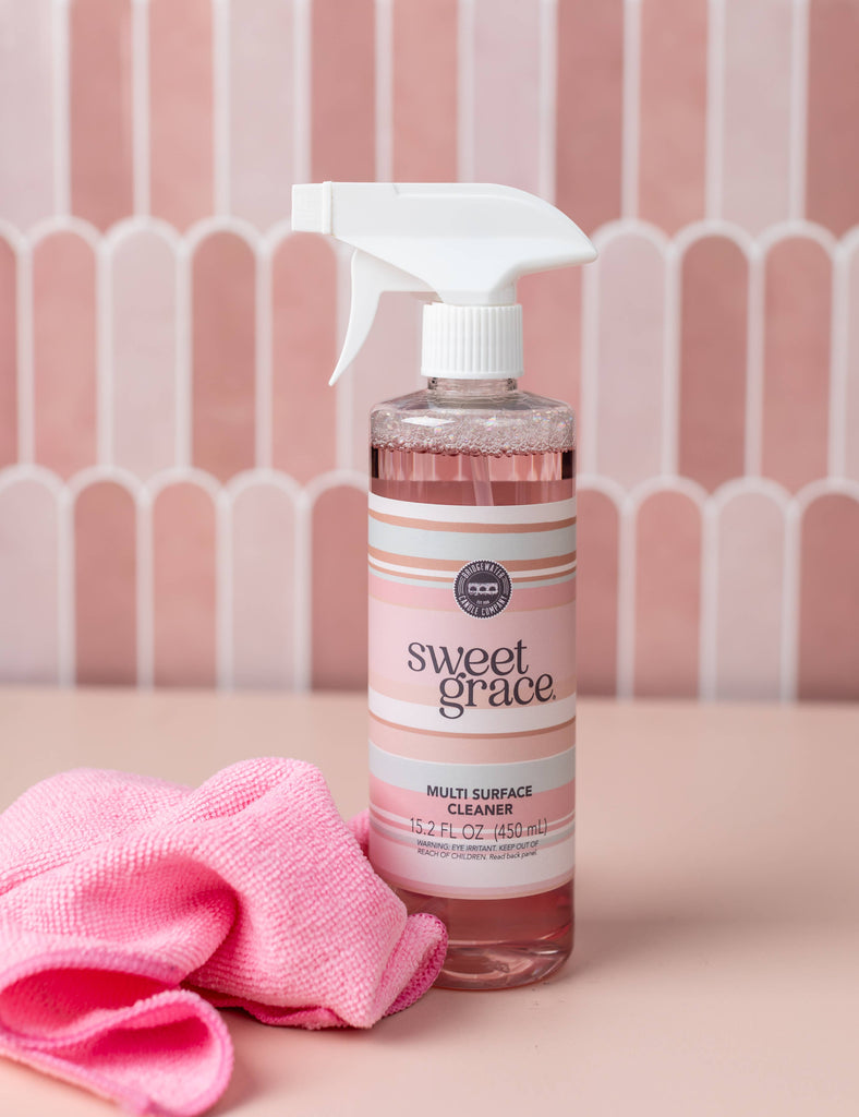 Bottle of sweet grace multi surface cleaner with a pink towel on a pink background