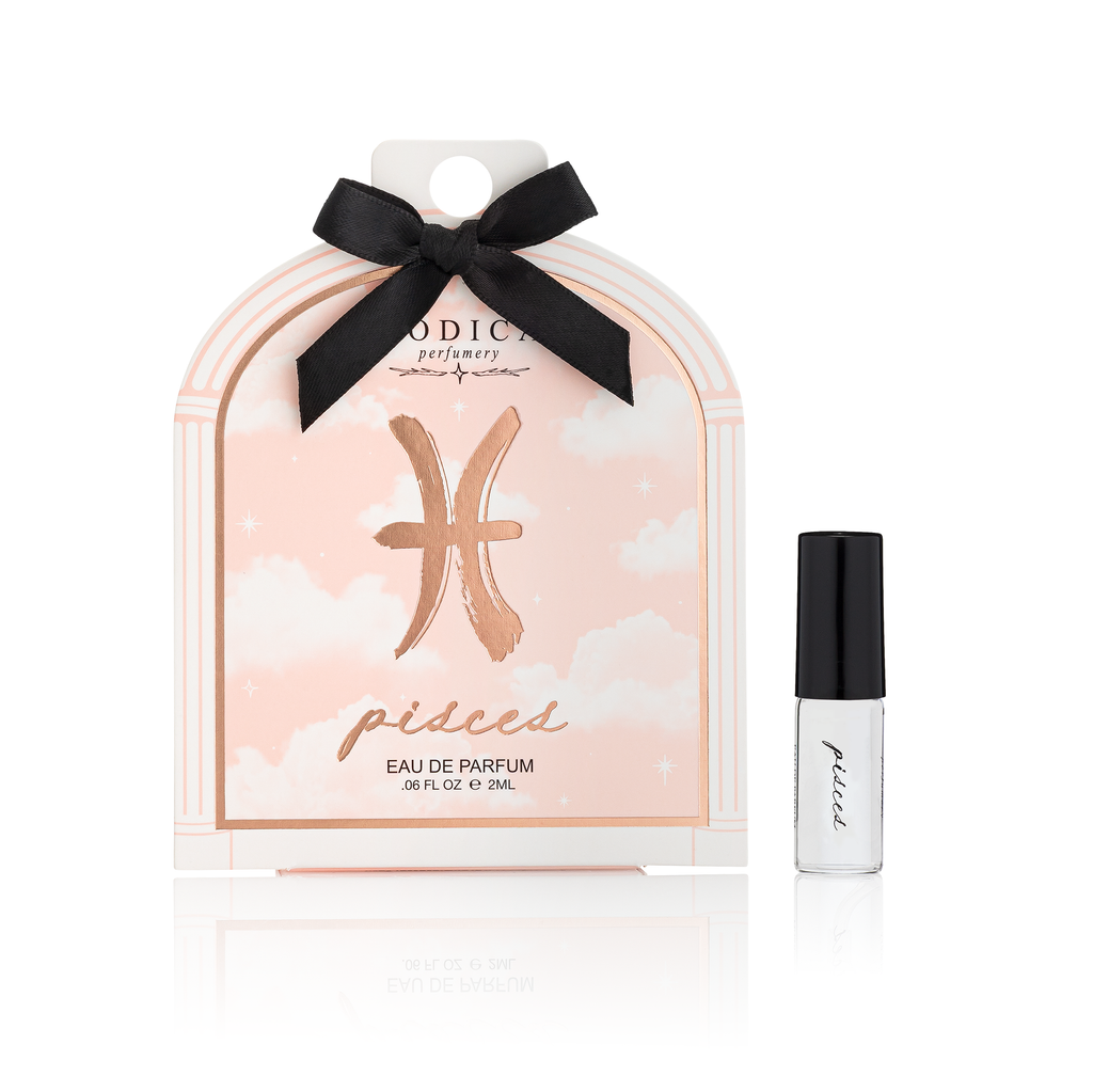 Perfume packaging with a black bow and 'Pisces' design on a white background