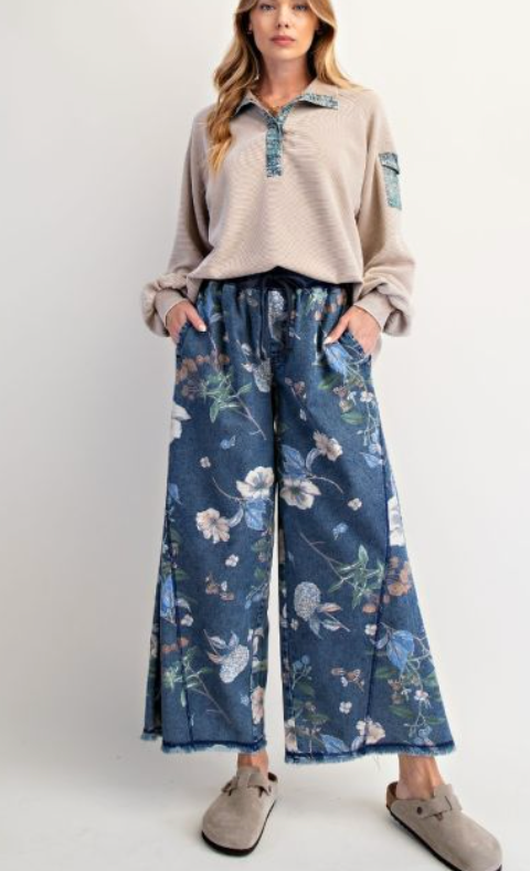 floral print wide-leg palazzo pants in indigo blue with a drawstring waist and raw hem, featuring a delicate botanical pattern for a comfortable and stylish look