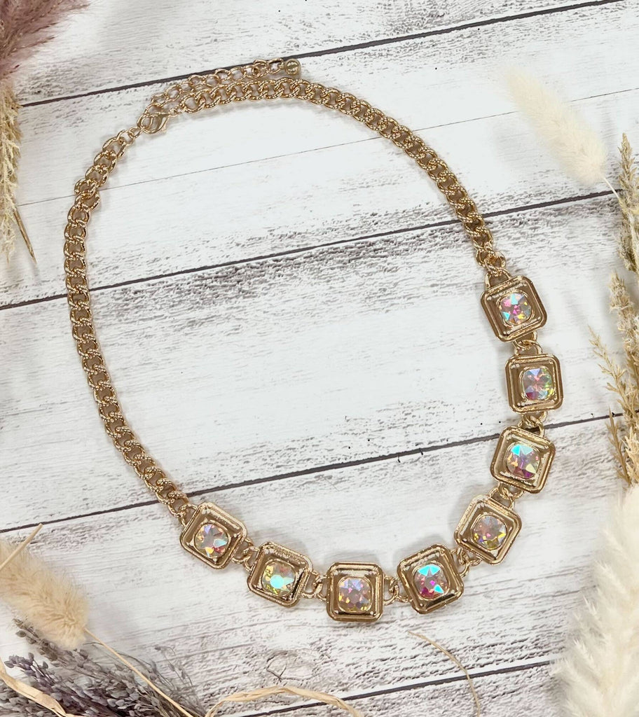 Gold chain necklace with square iridescent gemstones in gold frames.