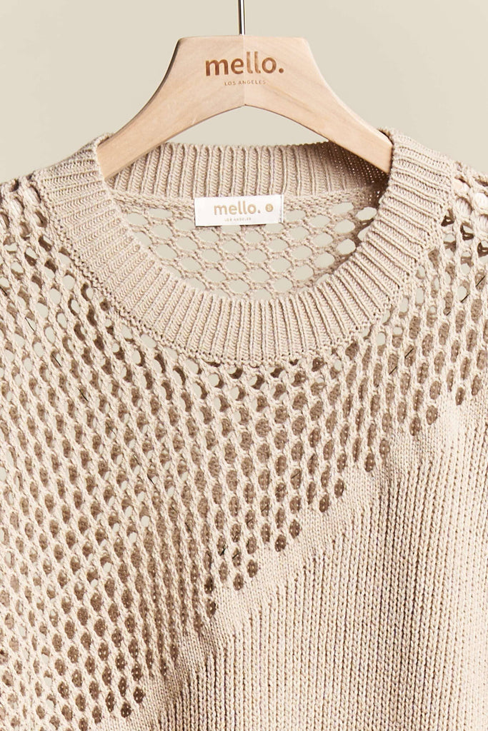 Beige knitted sweater on a hanger with 'mello' branding.