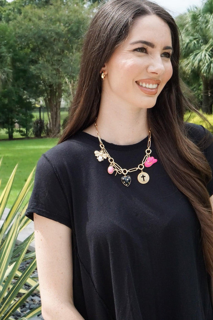 Woman wearing a black t-shirt with a colorful necklace outdoors