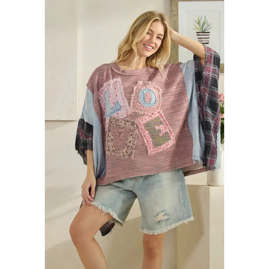 Boho-style oversized patchwork top with mixed fabric textures, relaxed fit, and creative detailing, modeled casually with denim.