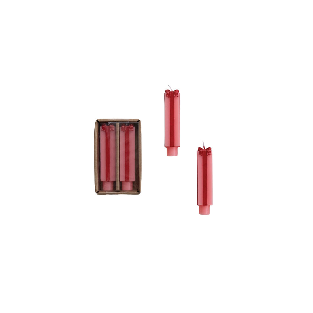 Set of two unscented paraffin wax taper candles in pink and red, designed in a package-inspired shape. Perfect for holiday tablescapes and mantel décor.